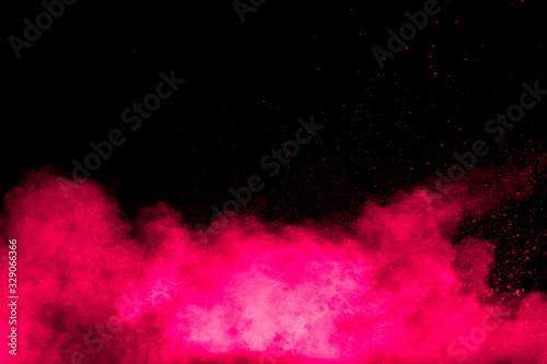 Explosion of pink colored powder isolated on black background.Pink dust splash.