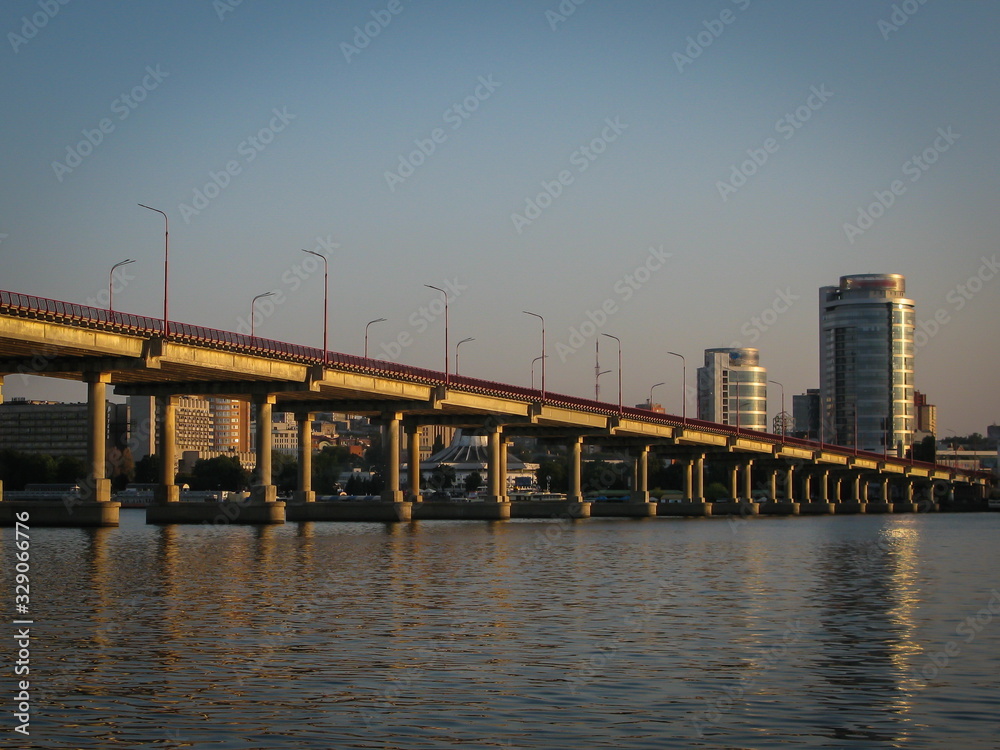 panoramic view of the city and the bridge across the Dnipro River, lit by the setting sun, Dnipro city, Ukraine