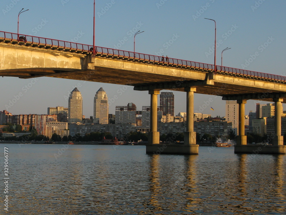 panoramic view of the city and the bridge across the Dnipro River, lit by the setting sun, Dnipro city, Ukraine