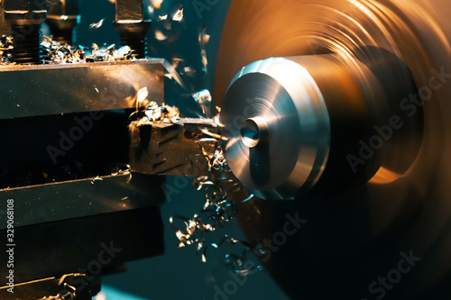 A turner grinds a part from an iron rod on a lathe. Metalworking parts on a lathe.