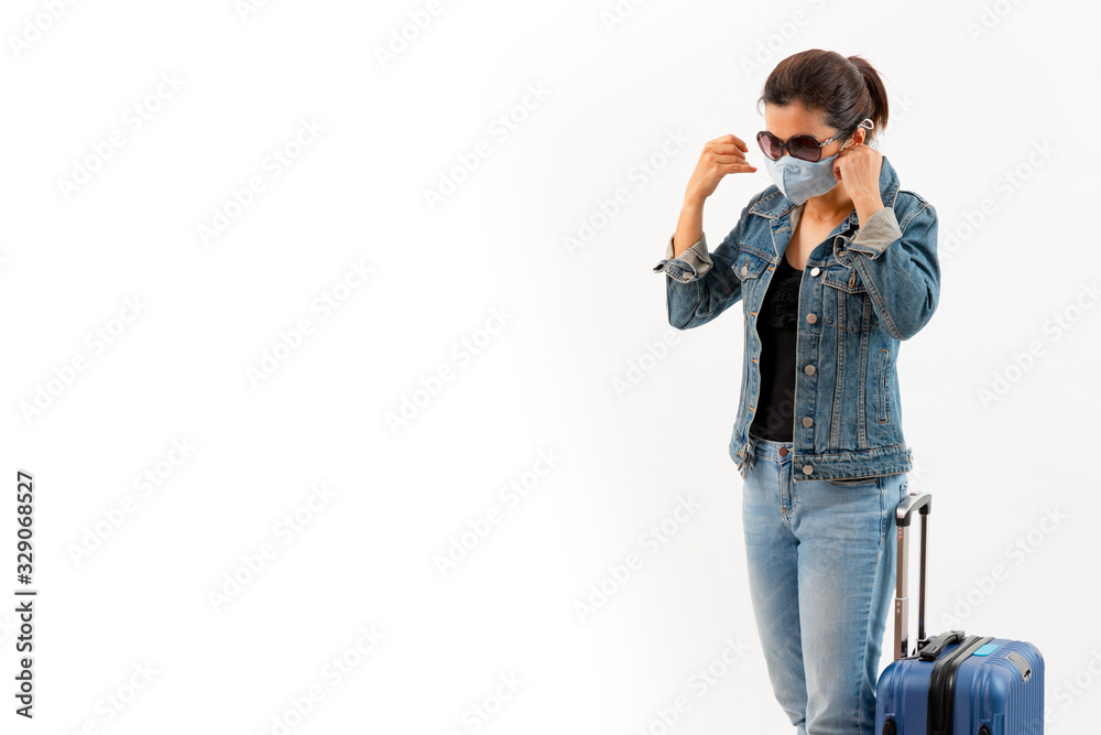 A tourist in medical mask stand near luggage isolate on white background . Novel COVID-19 coronavirus outbreak, Person prevents flu and corona virus infection. Travel and coronavirus concept. A tourist in medical mask stand near luggage isolate on white background . Novel COVID-19 coronavirus outbreak, Person prevents flu and corona virus infection. Travel and coronavirus concept.