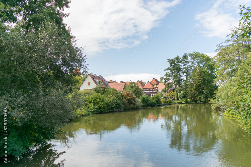 Durch Dinkelsbühl fließt der Fluss Wörnitz. Dinkelsbühl ist eine Stadt in Mittelfranken im Freistaat Bayern. Touristen aus der ganzen Welt besuchen Dinkelsbühl aufgrund der mittelalterlichen Altstadt.