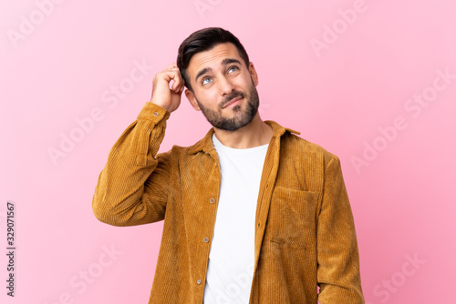 Bild auf Leinwand Young handsome man with beard wearing a corduroy jacket over pink background hav