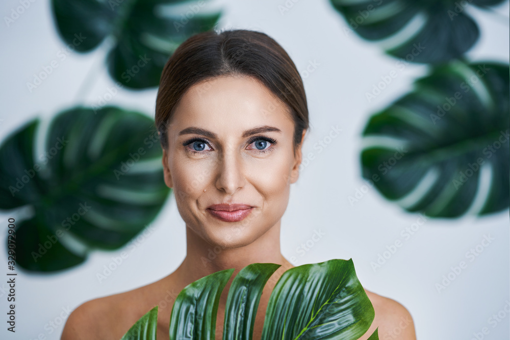 Beautiful adult woman posing against leaf background Beautiful adult woman posing against leaf background