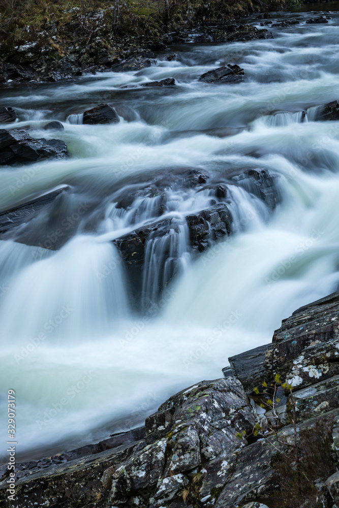 Long exposure shot of the waterfalls in Glen Orchy near Bridge of Orchy in the Argyll region of the highlands of Scotland during winter whilst the river is flowing fast from rainfall Long exposure shot of the waterfalls in Glen Orchy near Bridge of Orchy in the Argyll region of the highlands of Scotland during winter whilst the river is flowing fast from rainfall