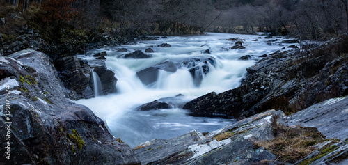 Long exposure shot of the waterfalls in Glen Orchy near Bridge of Orchy in the Argyll region of the highlands of Scotland during winter whilst the river is flowing fast from rainfall