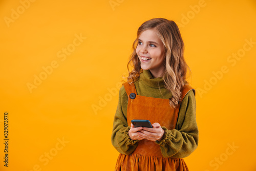 Happy young girl child isolated using mobile phone. © Drobot Dean