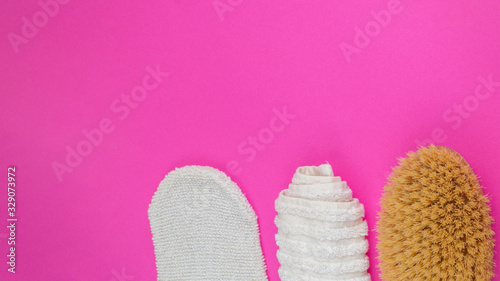 towel, peeling glove, body brush on pink background