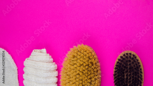 towel, peeling glove, body brush on pink background