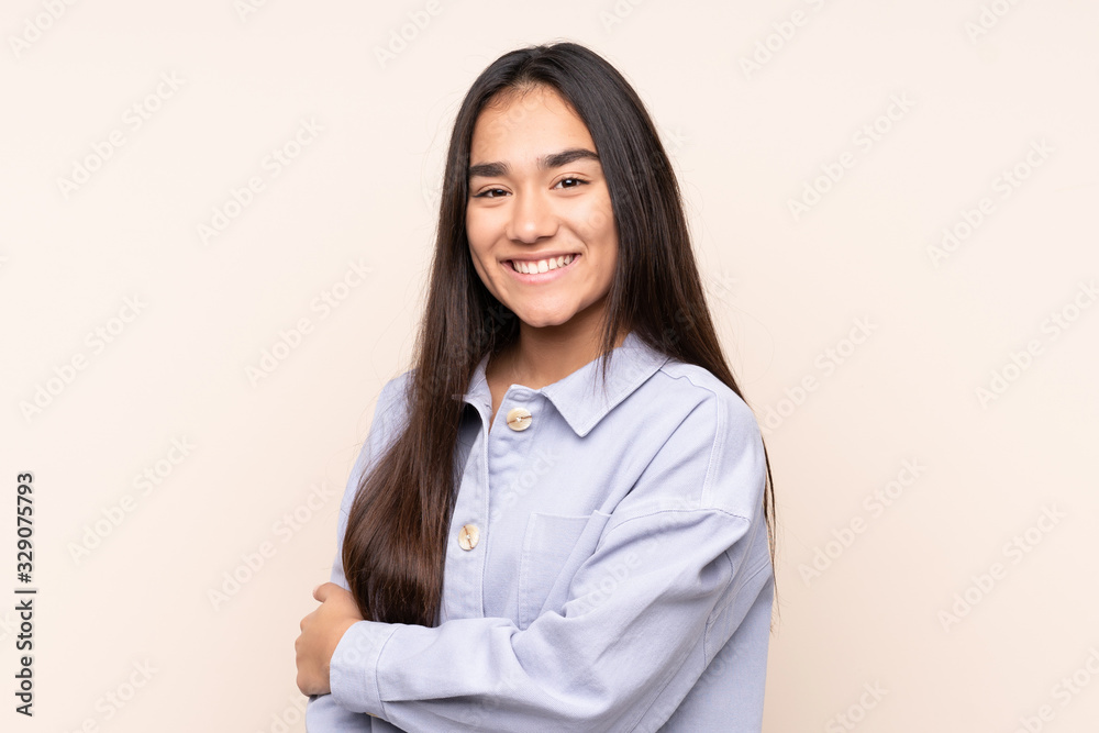 Young Indian woman isolated on beige background laughing Young Indian woman isolated on beige background laughing