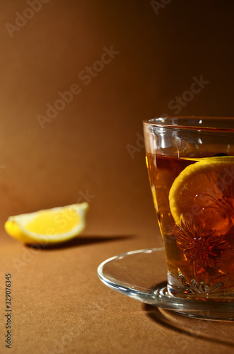 glass cup with tea and lemon on a brown background vertical orientation