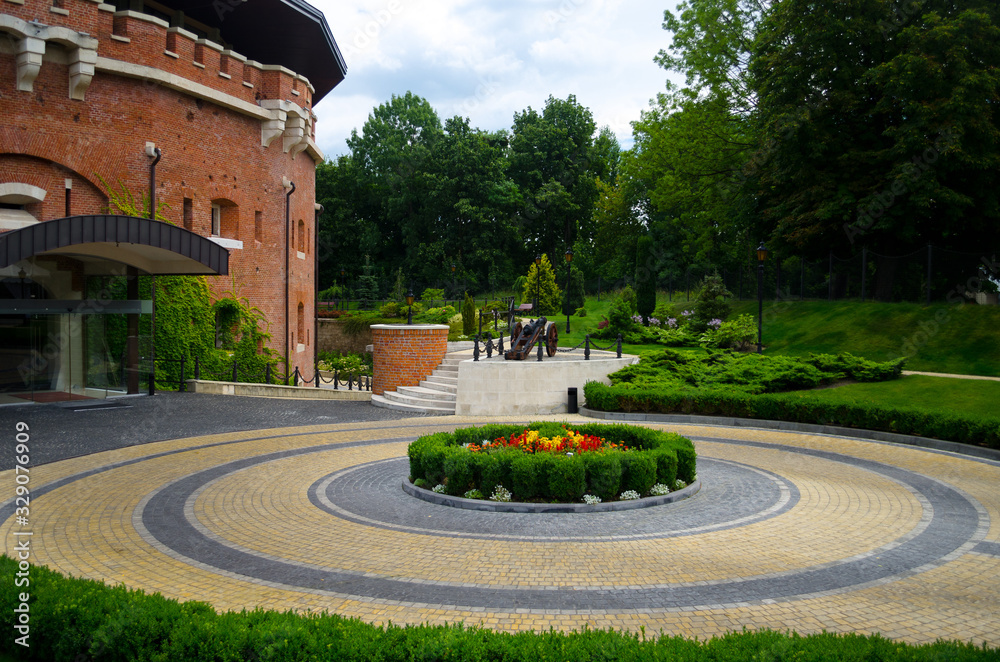 Obraz premium A picturesque landscaped garden at the citadel in Lviv. Fortification defensive brick building of the Middle Ages. Beautiful summer landscape for postcards and background. Lviv, Ukraine, July 23, 2017