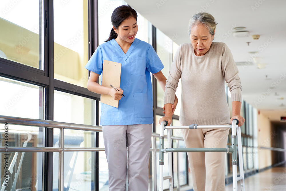Fototapeta premium asian old woman walking with a walker in rehab center