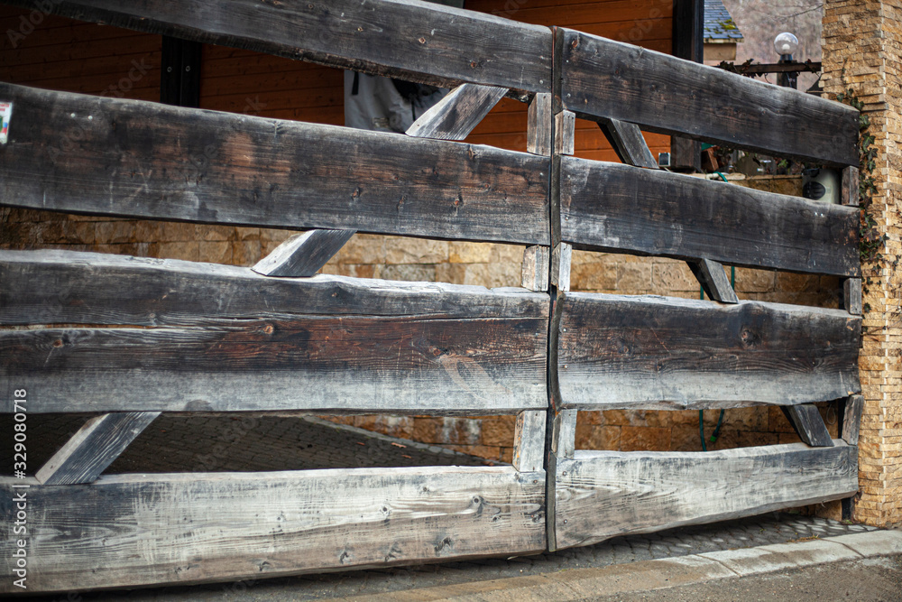 Wooden gate to the countryside. The fence on the farm. The construction of the boards. Check in for the car. Gate for cattle. Wooden gate to the countryside. The fence on the farm. The construction of the boards. Check in for the car. Gate for cattle.