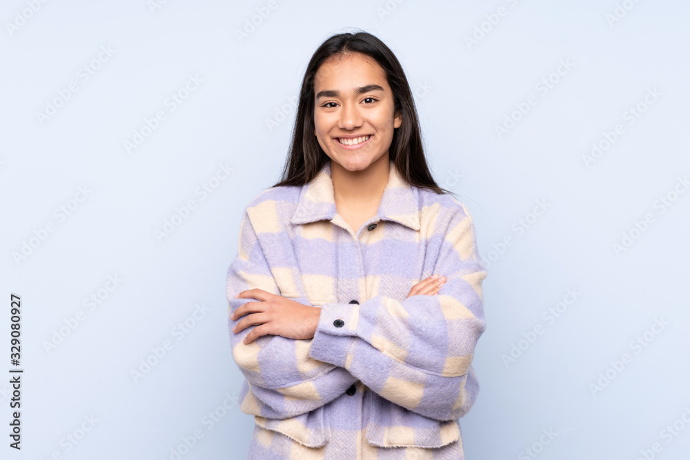 Young Indian woman isolated on blue background keeping the arms crossed in frontal position Young Indian woman isolated on blue background keeping the arms crossed in frontal position