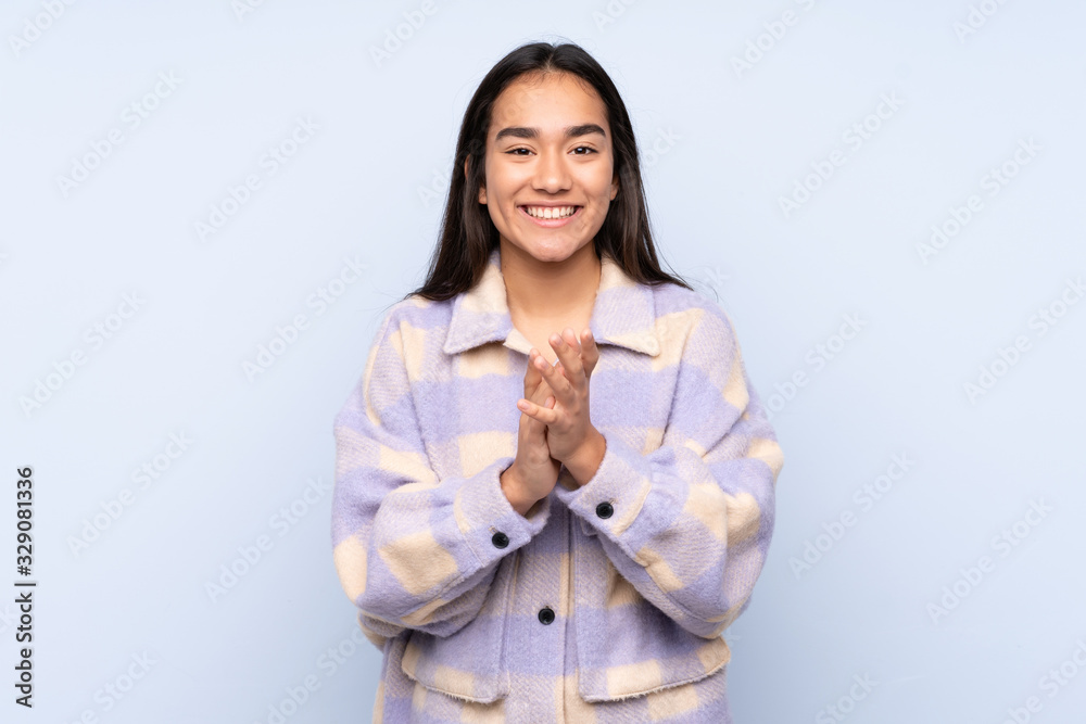 Young Indian woman isolated on blue background applauding after presentation in a conference Young Indian woman isolated on blue background applauding after presentation in a conference
