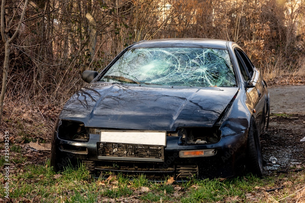 Stolen car left robbed without wheels and with broken windshield in the forest Stolen car left robbed without wheels and with broken windshield in the forest