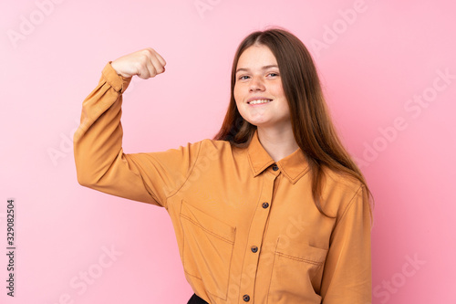 Ukrainian teenager girl over isolated pink background doing strong gesture © luismolinero