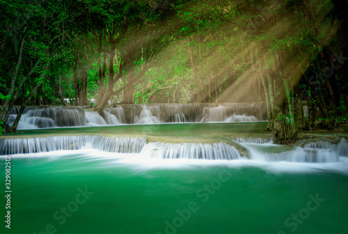 Fototapeta Naklejka Na Ścianę i Meble -  Beautiful waterfall with sunlight in autumn forest at Erawan National Park, Thailand, Nature landscape , Beautiful steam green forest nature