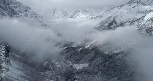 aerial nature landscape of Siguniangshan mountain valley in the mist pine tree forest under the clouds at winter day in Sichuan China  photo