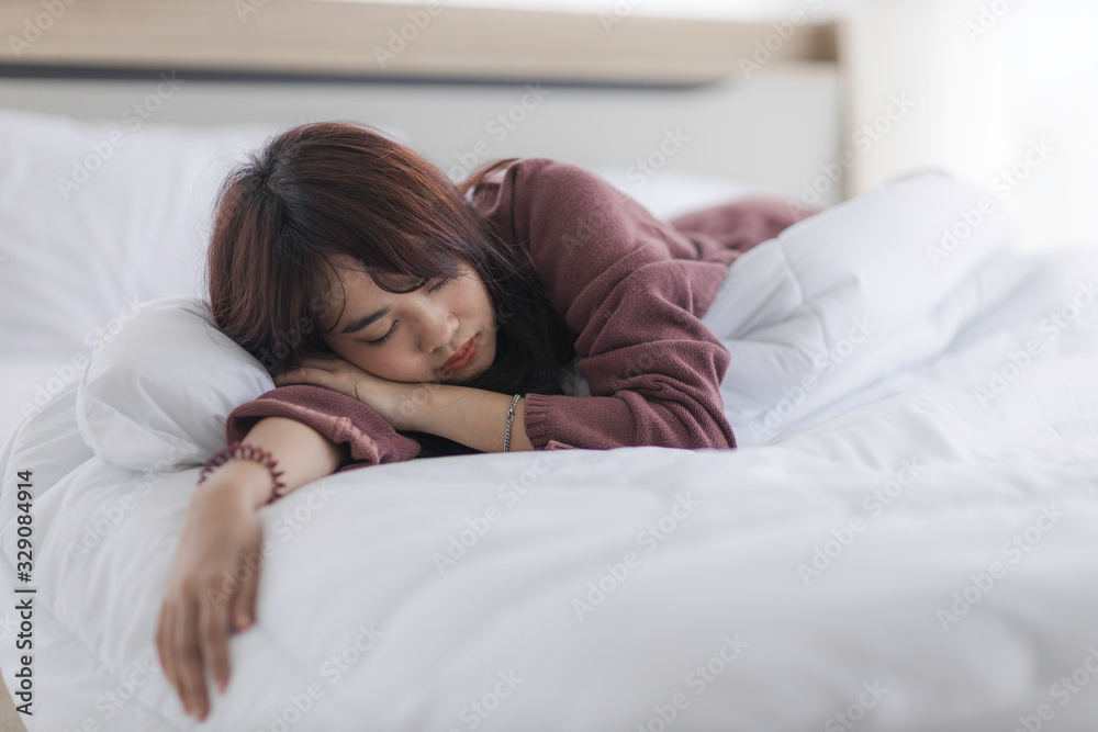 Asian woman is sleeping as a hangover from a party or asleep from exhaustion in her bed in the bedroom until the morning. Asian woman is sleeping as a hangover from a party or asleep from exhaustion in her bed in the bedroom until the morning.