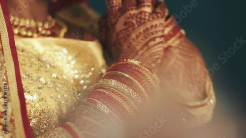 Close up details of indian bride's hands covered henna and bracelets