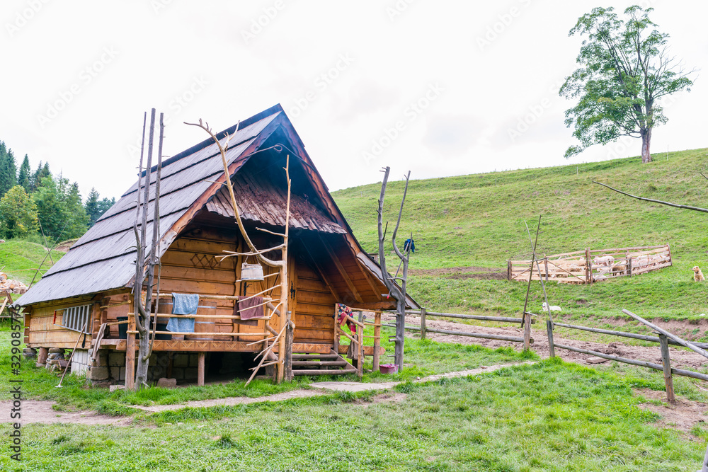 Wooden shepherd's hut in the mountains on a hillside Wooden shepherd's hut in the mountains on a hillside