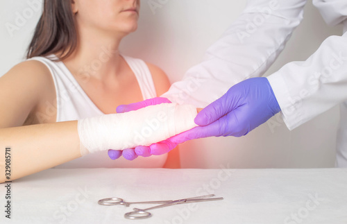 A surgeon doctor examines a patient s palm for a fracture or crack in a bone. Scaphoid fracture, red photo
