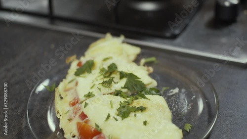 Wallpaper Mural Omelette on plate, seasoning with greens, slow motion, shallow depth of field Torontodigital.ca