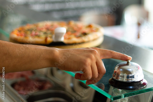 cozinheiro tocando a campainha pizza pronta