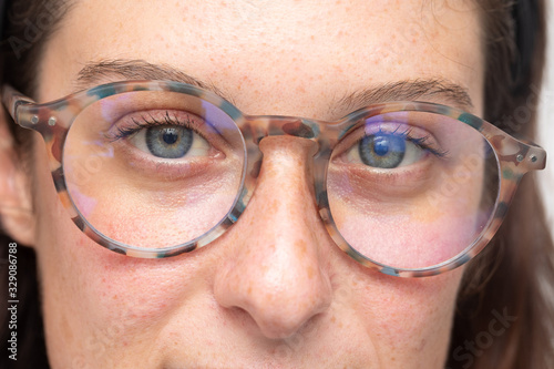 Detail of young woman face wearing eye relief glasses for computer fatigue