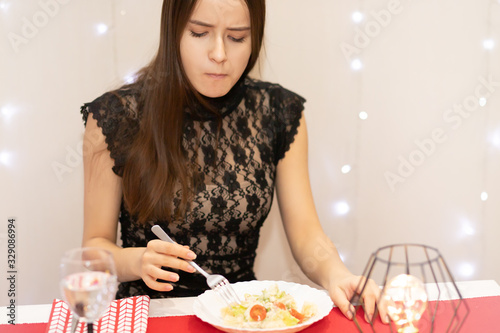 Slika na platnu The young woman in the restaurant is unhappy, ate something tasteless, spicy, wa