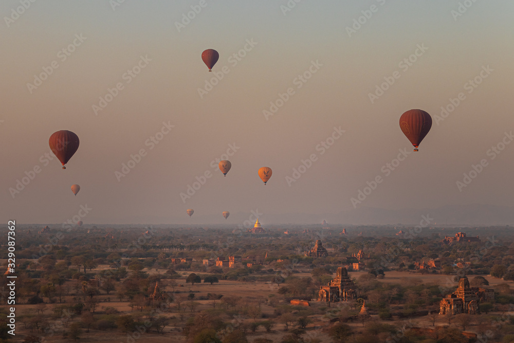 Naklejka premium Beautiful View of Bagan at Sunrise with Hot Air Balloons over Temples Stupas Pagodas