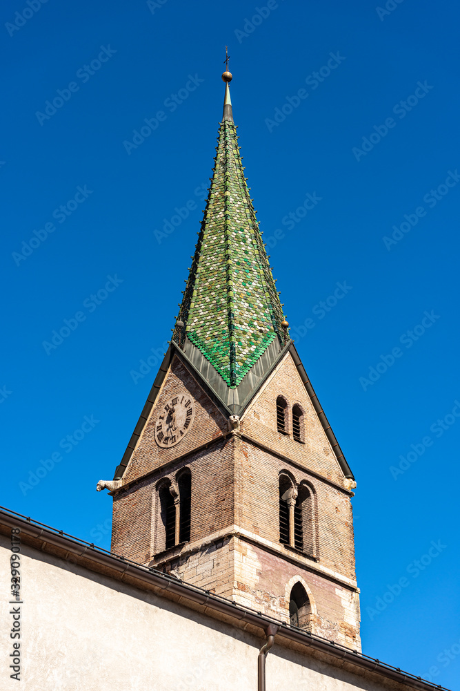 Trento, closeup of the Bell tower of the Church of Santi Pietro e Paolo with green majolica roof tiles (XV century). Trentino-Alto Adige, Italy, Europe