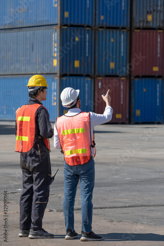 Foreman control loading containers box from cargo freight ship for import export, Foreman control industrial container cargo freight ship, Business import and export logistic concept.