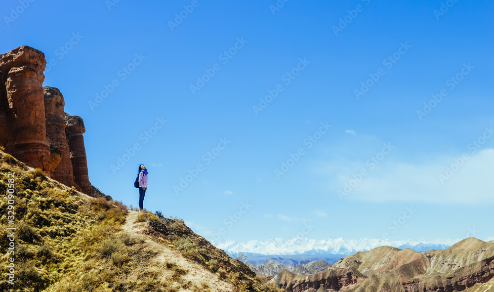 Girl looking far on hillside in Binggou Danxia Scenic Area