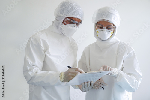 doctor and nurse wearing PPE and looking for corona/covid-19 virus infected patient's laboratory report