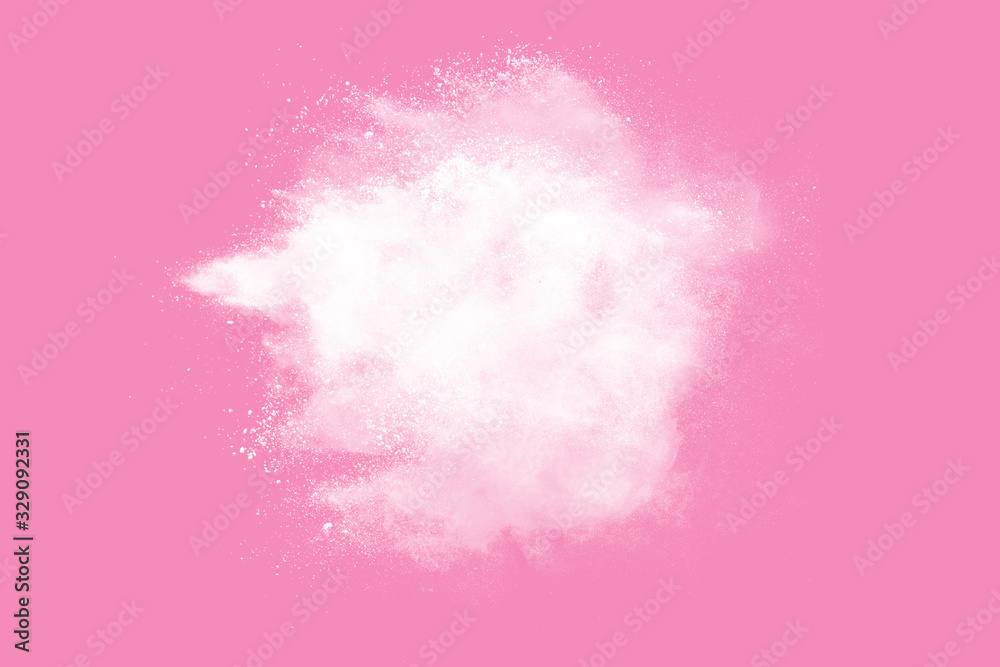 Abstract white powder explosion. Closeup of white dust particle splash isolated on pink  background.