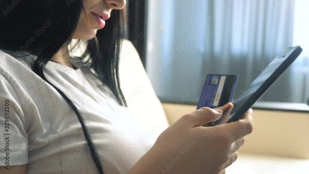 girl makes online sale shopping concept with laptop digital tablet. brunette lying on couch watching shop online paying credit card. online shop lifestyle score girl makes online sale shopping concept with laptop digital tablet. brunette lying on couch watching shop online paying credit card. online shop lifestyle score
