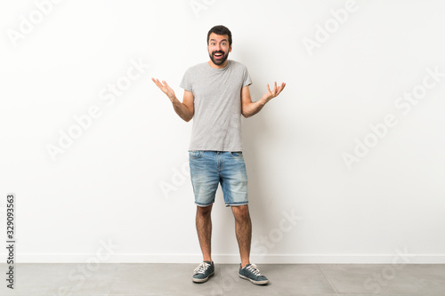 Fotografi A full-length shot of handsome man with beard with shocked facial expression