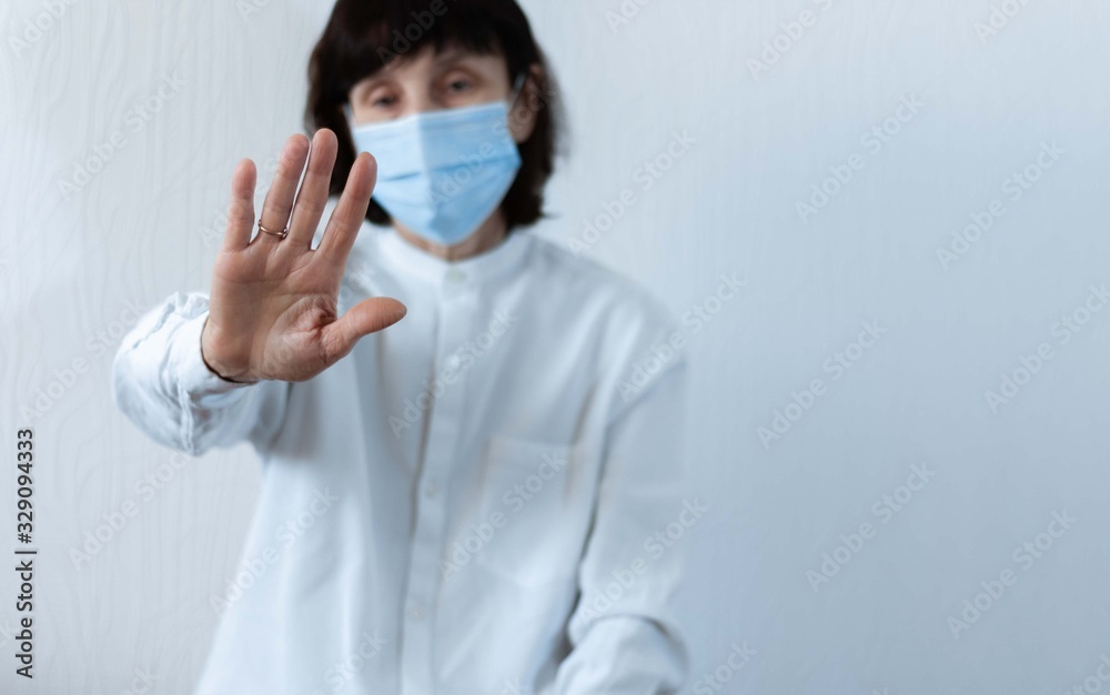 Coronavirus quarantine and Air pollution pm2.5 concept. Old sick woman wearing blue respirator mask for protect with outstretched arm. Wuhan, China epidemic virus symptoms background.