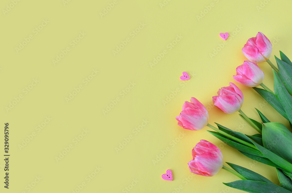 Pink tulip flowers in envelope on yellow background. Floral arrangement