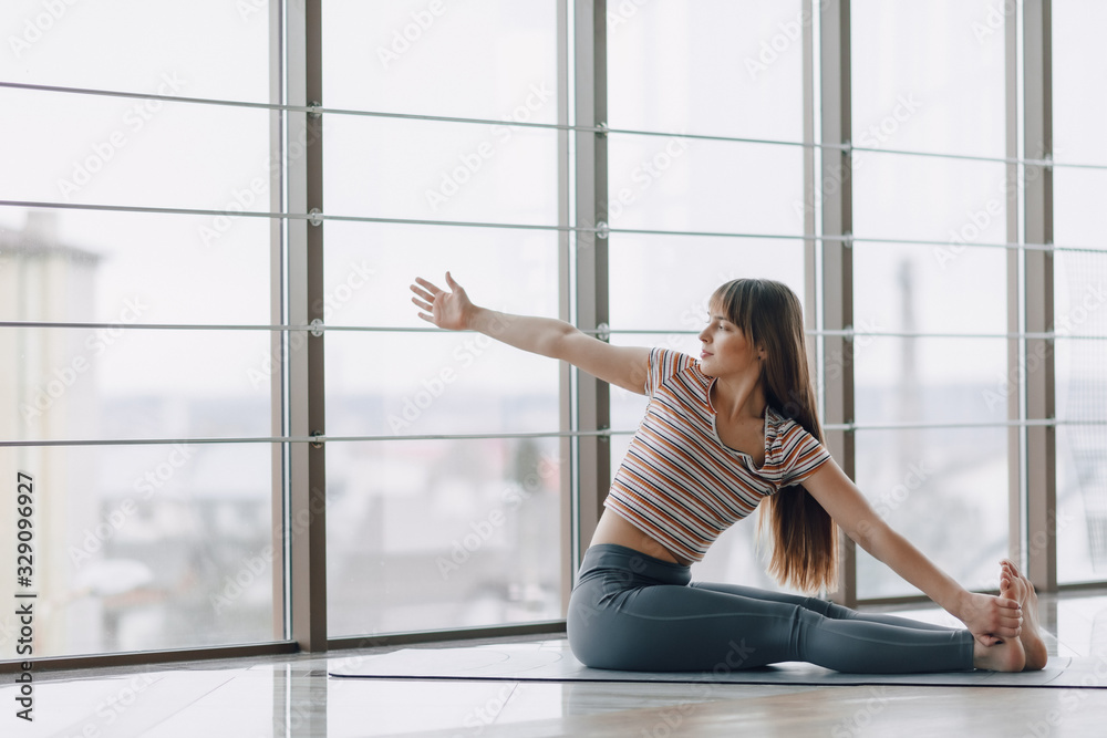 pretty attractive girl doing yoga and relaxing in the bright room