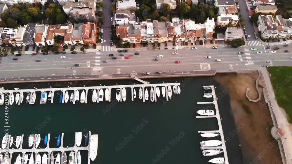 parked yachts in a bay at sunset along a city road and ocean. aerial video shoot parked yachts in a bay at sunset along a city road and ocean. aerial video shoot