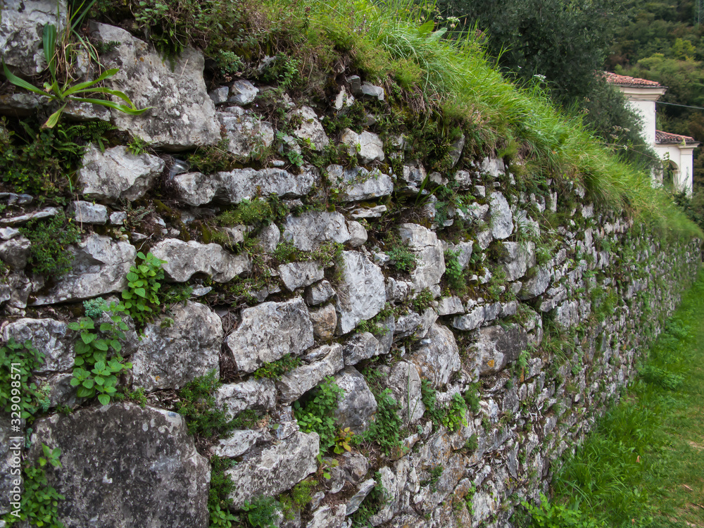 ancient stone wall on the way to Sacred Mount of Ossuccio, Our Lady of Help Sanctuary, lake Сomo, Tremezzina, Italy