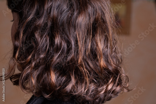 Medium length clean shiny hair with natural waves. Blurred background with some copy space