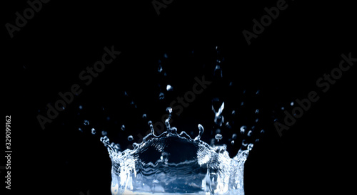 Water splash and drops isolated on black background.