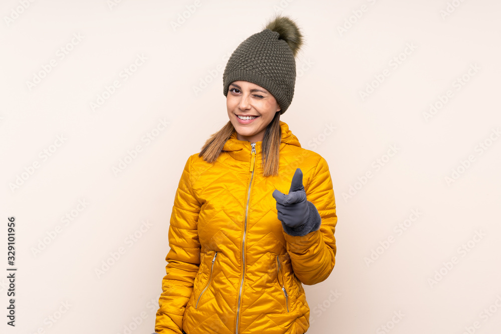 Woman with winter hat over isolated background points finger at you Woman with winter hat over isolated background points finger at you