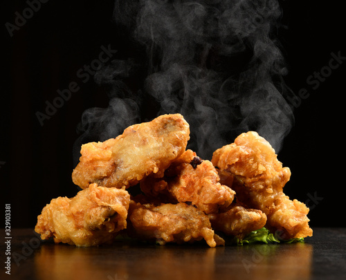 Obraz na płótnie Hot and spicy bbq chicken wings with with green salad leaf and steam smoke w salonie