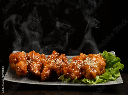 Hot and spicy bbq chicken wings with with green salad leaf and steam smoke
